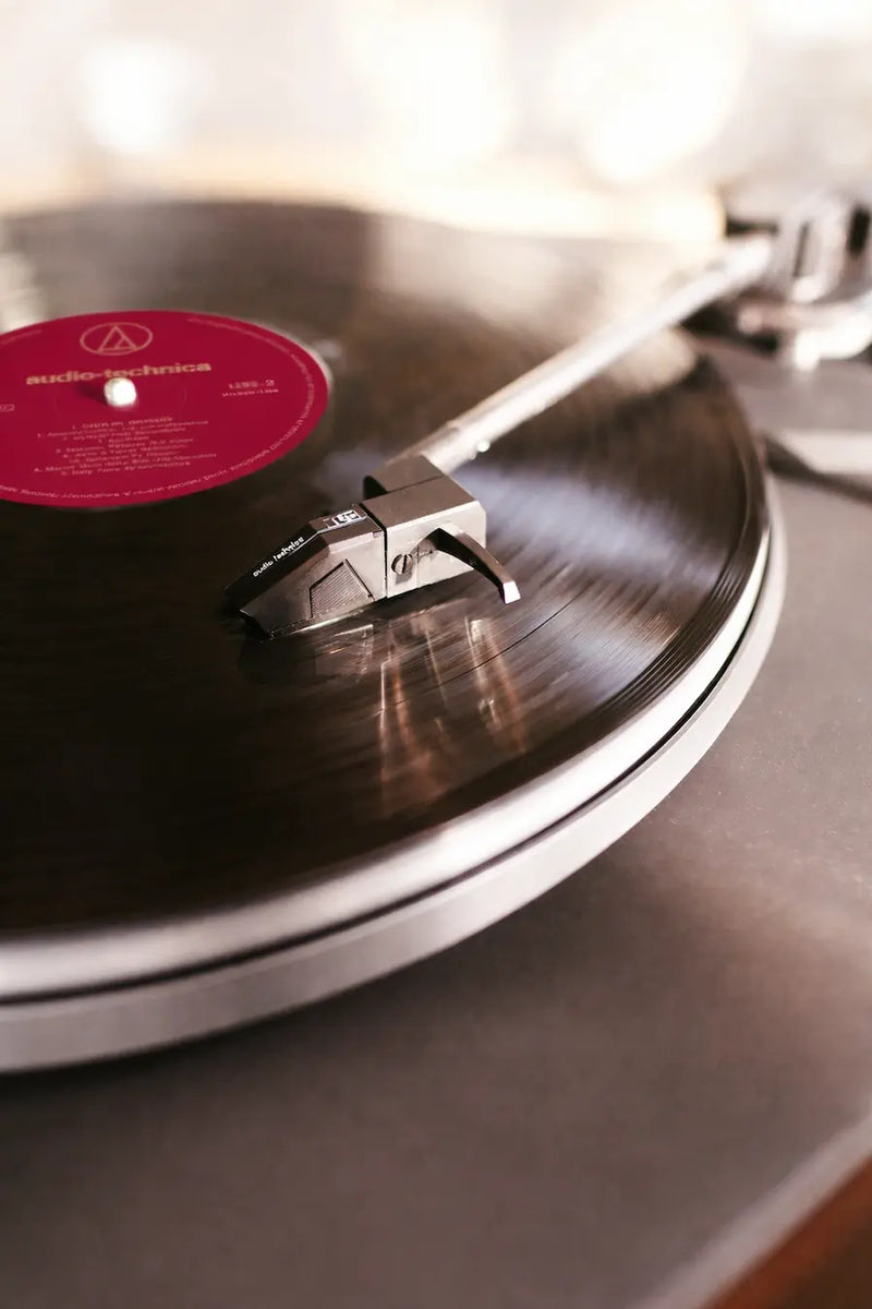 A close-up shot of a turntable needle playing a custom vinyl record, showcasing superior audio playback quality