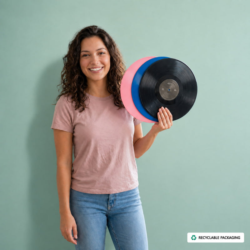 Smiling woman holding black, pink, and blue custom vinyl records with recyclable packaging message on a mint green background.